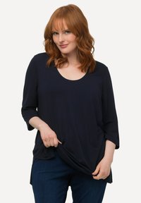 Navyblaues ¾-Ärmel T-Shirt mit Rundhalsausschnitt, aus weichem Stoff gefertigt. Verfügt über eine lockere Passform und seitliche Schlitze am Saum.