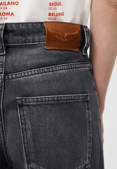 Σκούρα γκρι τζιν από τζιν ύφασμα με υφή, που διαθέτουν καφέ δερμάτινο πάπυρο με λογότυπο φτερού στο ύψος της μέσης και δύο πίσω τσέπες.