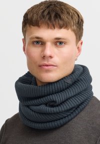 Tumehall ribakootud kaelus, millel on paks ja tekstuuriga disain ning väikene logo detail. Kandmine kaelal lõdvalt.