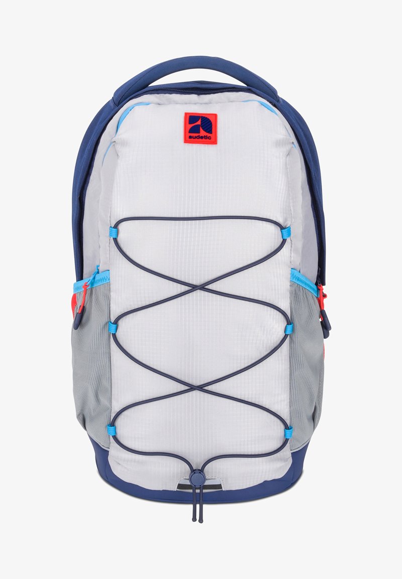 Grå och marinblå ryggsäck med en strukturerad yta, som har en framträdande bungee-snodd design, sidofickor och en tydlig röd logotyp på toppen.