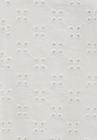 Tissu blanc avec des motifs floraux brodés en œillets répétitifs, reliés par de petites lignes cousues.
