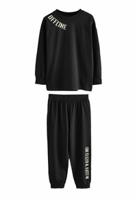 Ensemble de vêtements d'intérieur noirs en coton doux. Le haut à manches longues arbore le texte "OFFLINE", et le pantalon à taille élastique présente un accent de texte sur le côté.