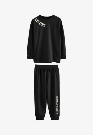 Ensemble de vêtements d'intérieur noirs en coton doux. Le haut à manches longues arbore le texte "OFFLINE", et le pantalon à taille élastique présente un accent de texte sur le côté.