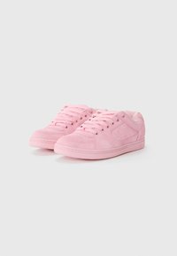 Pink suede sneakers with a textured finish, featuring round laces, perforated side accents, and a low-profile sole design.