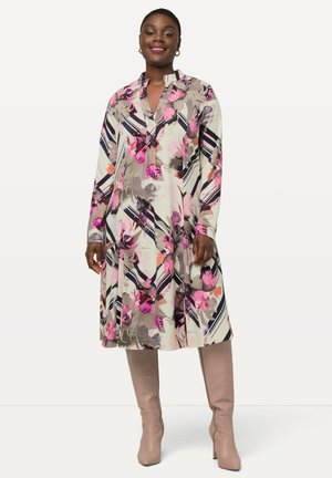 Abito di tessuto leggero con stampa floreale in rosa, grigio e nero, dotato di colletto e maniche lunghe, abbinato a stivali beige al ginocchio.