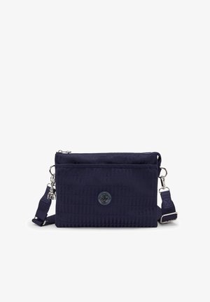 Mørkeblå rektangulær crossbody taske med justerbar rem, struktureret stof, front lynlås lomme og rund logo-patch i midten.