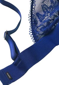 Reggiseno blu in pizzo con fascia in satin testurizzato e spalline regolabili. Presenta dettagli in pizzo intricati lungo il bordo superiore e un'etichetta sulla fascia.