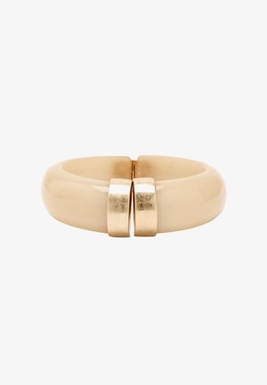 Beżowa bransoletka w formie bangla z gładkim, błyszczącym wykończeniem; posiada złote metaliczne akcenty w centrum, tworząc wzór zapięcia.