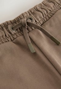 Braune Shorts mit elastischem Bund und Kordelzug mit grünen Kunststoffakzenten sowie strukturiertem Stoff mit glatter Oberfläche.