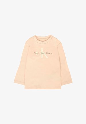 Jasnopomarańczowa koszula z długim rękawem z okrągłym dekoltem, z małym, wypukłym logo "Calvin Klein Jeans" w tonacji kolorystycznej. Wykonana z miękkiego materiału bawełnianego.