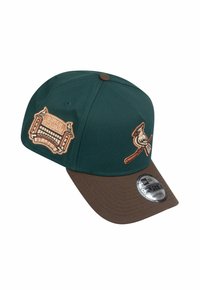 Casquette verte avec une visière marron ornée d'un design brodé du Busch Stadium et d'un oiseau cardinal. Sangle ajustable avec une étiquette 9FORTY.