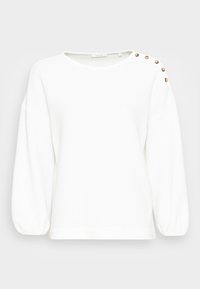 White knit sweater with a relaxed fit, round neckline, and balloon sleeves. Features three decorative buttons at the left shoulder.