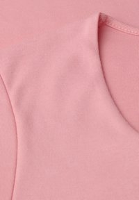 Helles rosa Gewebe mit glatter Textur, featuring einem runden Ausschnitt und elastischem Rippstrick. Nahaufnahme des Textilmusters.