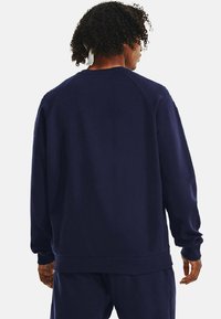 Sudadera azul marino de tejido suave, con escote de tripulación y mangas raglán largas, con puños y bajo de canalé.