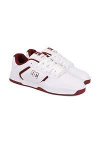 Biele tenisky s marhuľovými akcentmi, s logom na boku, textúrovaným jazykom a bielymi šnúrkami. Gumová podrážka s viditeľným vzorom.