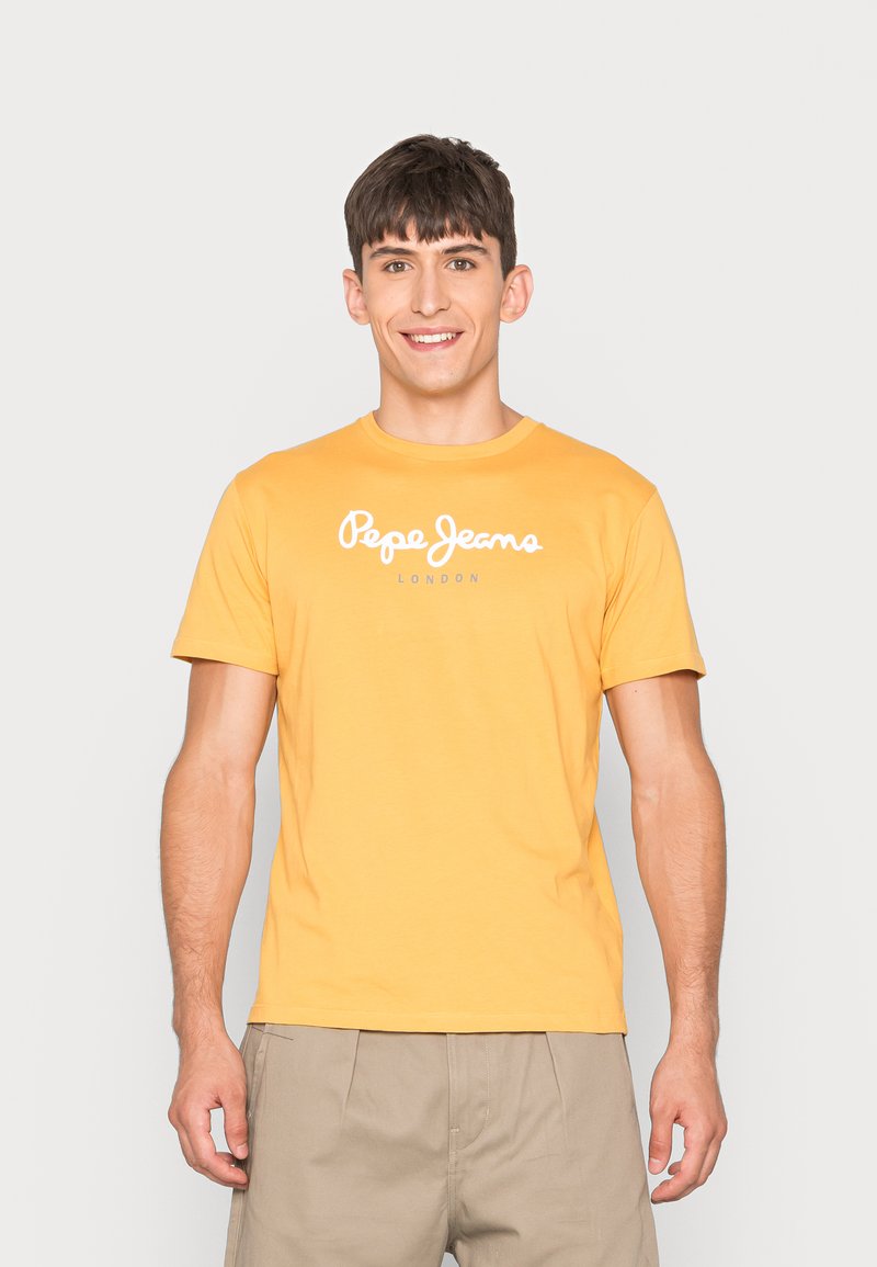 Geltonas trumpas rankovės marškinėlis su baltu „Pepe Jeans“ logotipu ir „LONDON“ tekstu. Minkštas audinys, apvalus kaklas ir laisvas pjūvis.