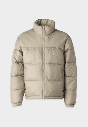 Tan pufferjacka med hög krage, dragkedjefront och elastiska ärmslut. Har quiltad textur och boxig design.