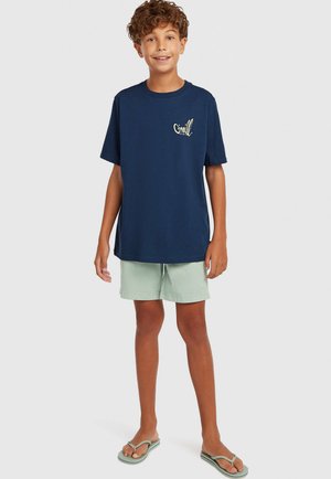 Granatowy bawełniany t-shirt z logo, w zestawie z jasnobeżowymi szortami i japonkami, charakteryzujący się luźnym krojem i prostym wzornictwem.