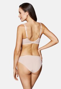 Jasnoróżowy zestaw biustonosza i bikini wykonany z gładkiego materiału, z regulowanymi ramiączkami i zapięciem na haczyk z tyłu.