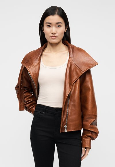 Brun läderjacka med vid krage, dragkedja och tryckknappar. Jackan har en slät textur och en skräddarsydd passform.