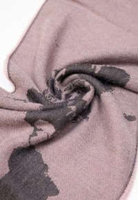 Sciarpa rosa chiaro con una texture morbida, caratterizzata da un motivo astratto scuro e un bordo chiaro a contrasto. Elegante avvolta a spirale.