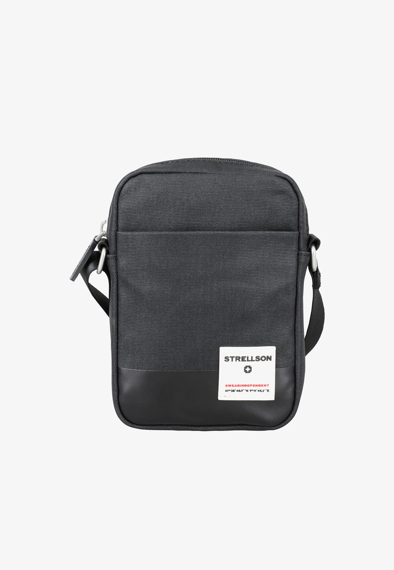 Borsa a spalla nera in tela con base nera liscia, chiusura con zip, tasca frontale e un'etichetta con testo bianco e rosso. Design compatto.