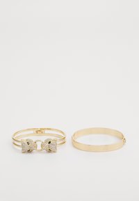Două brățări din aur: una are un închizător decorativ cu pietre strass și accente verzi, cealaltă este un simplu band de aur neted.