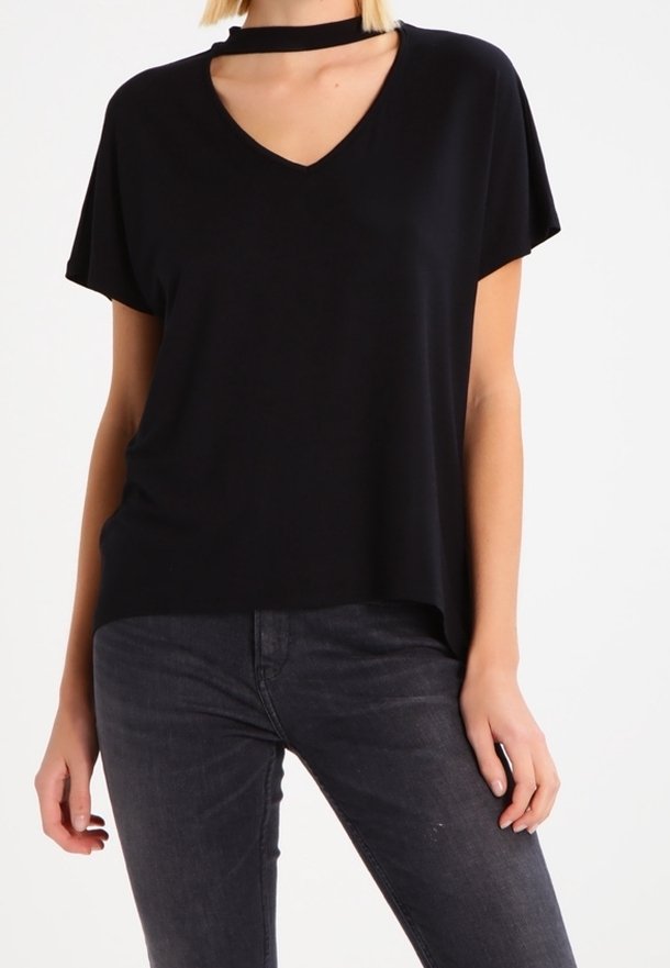 Camiseta negra de manga corta con cuello en V y detalle de gargantilla. Fabricada con una tela suave, de corte holgado y superficie ligeramente texturada.