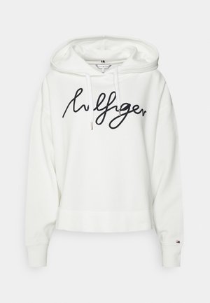 Weißer Kapuzenpullover mit einem schwarzen, kursiven Logo, Kordelzug-Haube, gerippten Bündchen und einem cropped Design mit einem sichtbaren Etikett auf der Innenseite.