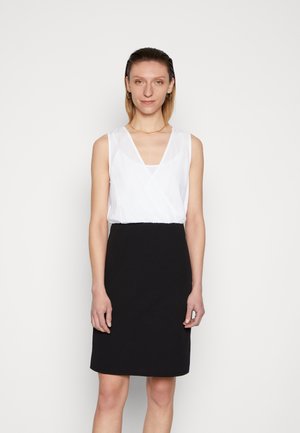 Vestido sem mangas com parte de cima branca e decote em V, e saia preta até ao joelho. Fabricado em diferentes texturas de tecido, com acabamento suave.