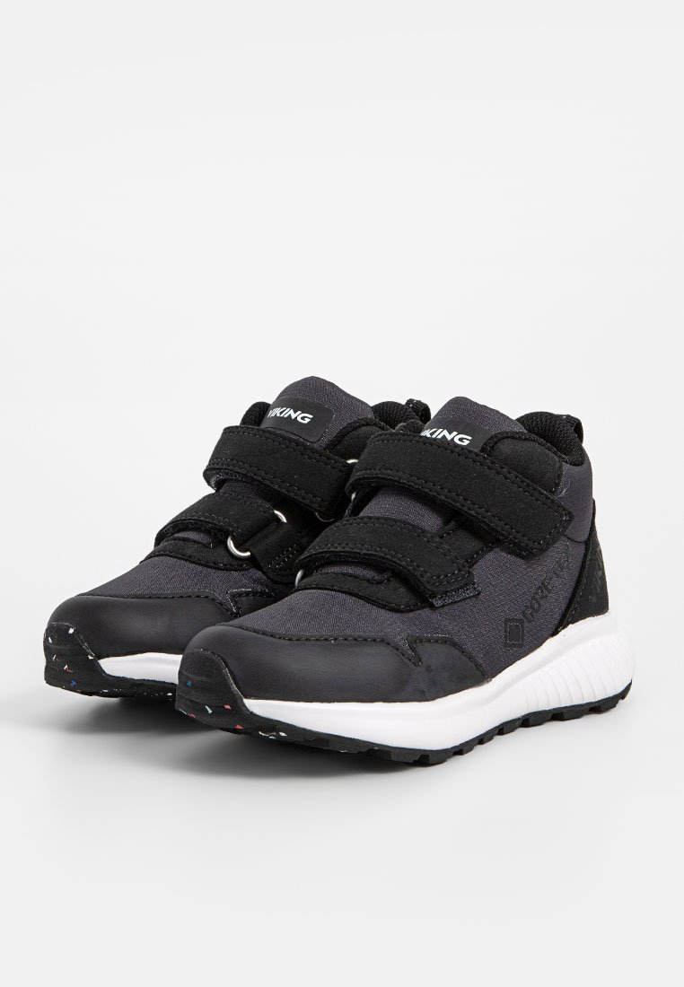 Schwarze Sportschuhe aus Mesh- und Leder Materialien, ausgestattet mit Klettverschlussriemen, einer gepolsterten weißen Sohle und strukturiertem Gummiprofil.