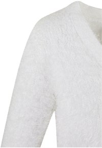 Pull blanc pelucheux avec un design en V et des manches longues. La texture est douce avec une finition légèrement transparente et duveteuse.