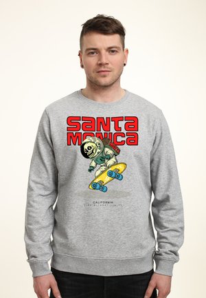 Grijze sweatshirt met een afbeelding van een skateboarder in een ruimtepak. De tekst luidt "SANTA MONICA" in het rood met een gele skateboard en blauwe wielen.