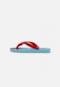 Chanclas de goma roja con una suela interior texturizada azul que presenta un diseño impreso, forma curva y suela plana.