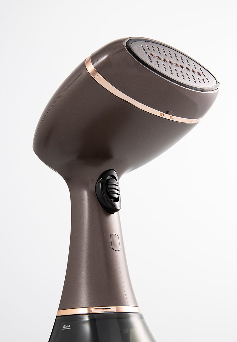 Steamer de prendas de mano en marrón oscuro con un acento en oro rosa. Presenta un diseño suave y curvado, una boquilla ventilada y un dial de control.