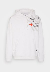 Bílá fleecová mikina s kapucí, s texturou posypanou barevnými tečkami, klokaní kapsou a grafikou včetně loga a textu v červené a šedé barvě. Obsahuje nastavitelné kapuci.