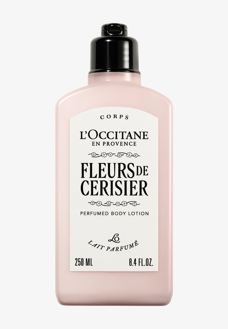 Lotion per il corpo profumata Fleurs de Cerisier di L'Occitane in una bottiglia di plastica rosa con pompa nera, caratterizzata da un'etichetta bianca testurizzata e testo nero.