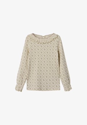Blusa di crema con scollatura arricciata, maniche lunghe e polsini elastici. Presenta un motivo a diamante con accenti floreali verdi.