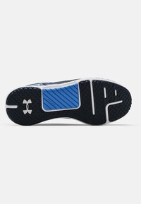 Atletisk sko sula i mörkblått och vitt. Har mönstrad gummi för grepp, en mönstrad blå accent och vit logotypdetalj.