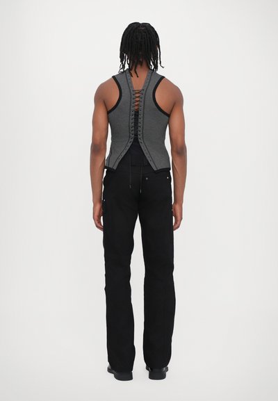Haut sans manches gris avec détail lacé au dos, complété par un pantalon noir à coupe droite. Tissu lisse au design minimaliste.