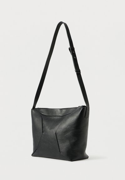 Fekete bőrből készült válltáska texturált felülettel, geometrikus mintával, cipzárral záródik, és állítható pánttal rendelkezik. Kompakt és minimalista forma.