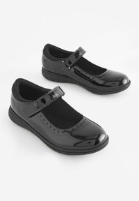 Schwarze lacklederne Mary Jane Schuhe mit runder Zehe, verstellbarem Riemen und gepolsteter Innensohle. Mit perforierten Details entlang der Kante.