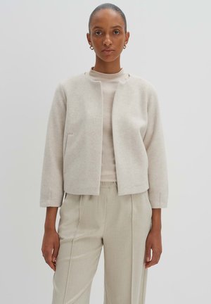 Light beige cropped jacket in soft wool blend, featuring a round neckline, two side pockets, and three-quarter length sleeves.