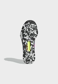 La suela del zapato presenta un patrón de camuflaje en blanco y negro, goma texturizada para mejorar la tracción, con un acento en amarillo brillante y el logo de Continental.