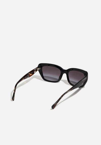 Mustat ylisuuret aurinkolasit kiiltävällä kehystyksellä, häilyvillä linsseillä ja kilpikonnakuosisilla sankoilla, joissa on hopeiset yksityiskohdat.