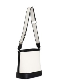 Canvas- och läderaxelväska i krämfärg och svart. Rektangulär form med justerbar rem och slät textur, med en svart botten.