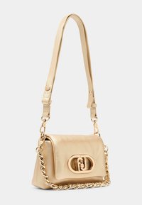 Beige lædertaske med en guldfarvet kædestrop, oval spænde og tekstureret overflade. Kompakt rektangulær form, rene linjer og minimale accenter.