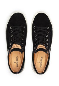 Des baskets en suede noires affichent une semelle en caoutchouc blanche, un bout rond et des lacets noirs, avec une fermeture éclair sur le côté et une marque en tan sur la semelle intérieure.