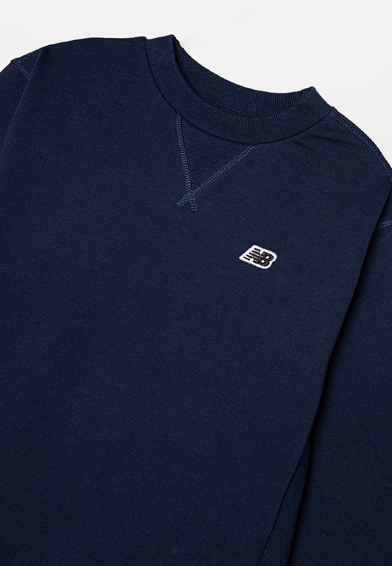 Sweatshirt bleu marine en mélange de coton, avec un col rond, des poignets côtelés et un petit logo blanc sur la poitrine. Texture douce.