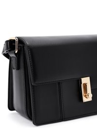 Borsa a tracolla nera in ecopelle con pattina, chiusura in oro, design strutturato e dettagli di cucitura visibili sulla parte anteriore e sui lati.